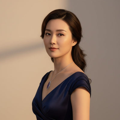 Woman wearing a dark blue dress with a necklace against a neutral background Elegant tanzanite necklace on model – designer gold jewelry for women by Tresor Collection