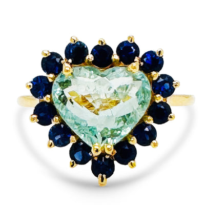 18K Gold Paraiba Tourmaline & Blue Sapphire Ring – Tresor Collection Heart-shaped Paraiba tourmaline and blue sapphire halo ring flatlay – luxury gold fine-jewelry design