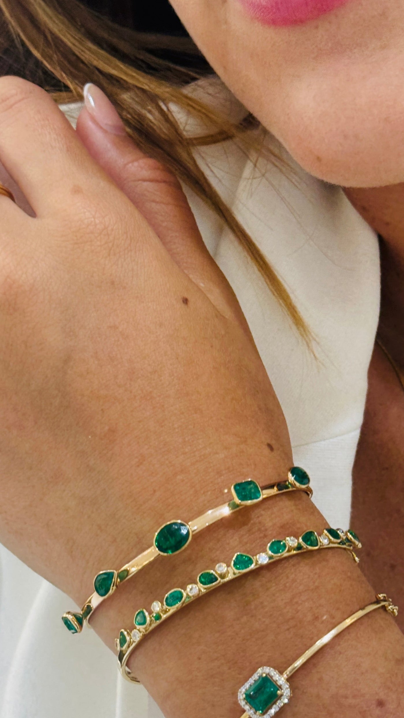 Model wearing gold emerald bangle on wrist – demonstrating the luxurious appeal of the bracelet in real life.