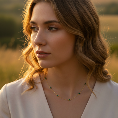 Elegant emerald gold necklace on model outdoors – designer jewelry for women by Tresor Collection