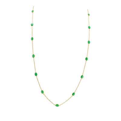 18K gold emerald station necklace flatlay – luxury fine jewelry by Tresor Collection
Gold necklace with green gemstones on a white background