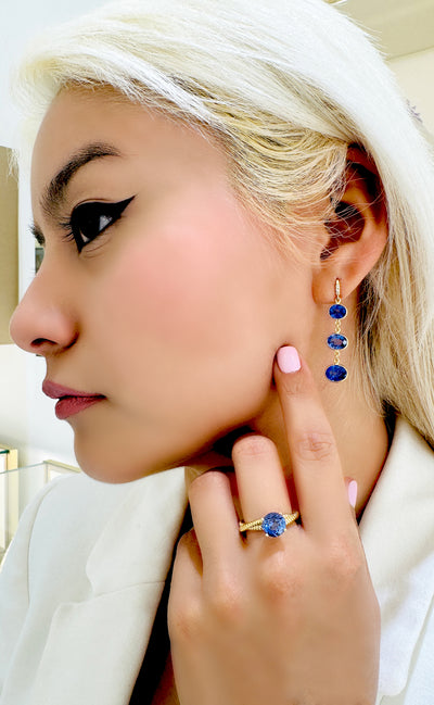 Tanzanite Oval & Diamond Earring In 18K Yellow Gold - Tresor Collection Profile shot of model wearing Tanzanite drop earrings – elegant blue gemstone jewelry