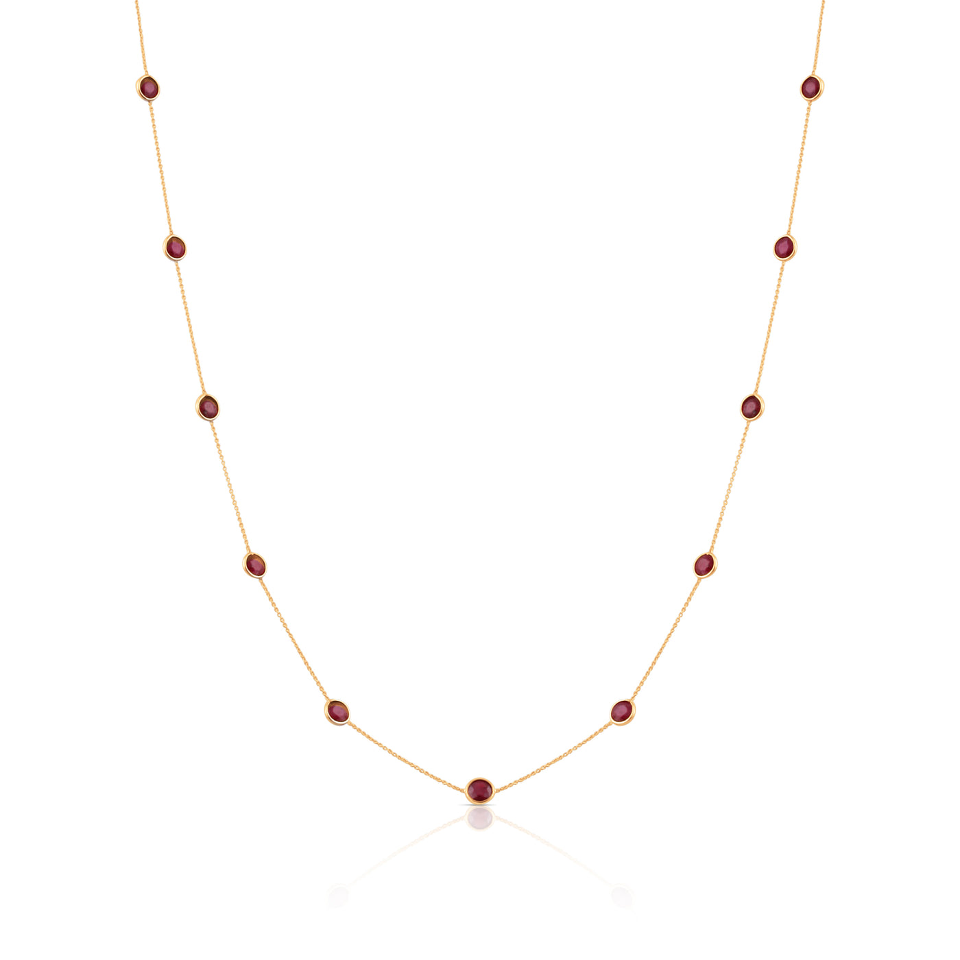 A round necklace made of 18k yellow gold with a series of red gemstones attached to it. 18K gold multi-gemstone necklace flatlay – luxury fine jewelry by Tresor Collection