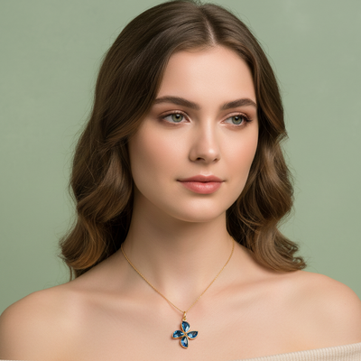 Woman wearing a necklace with a blue pendant against a green background Model wearing London Blue Topaz flower pendant necklace – elegant high-end jewelry look