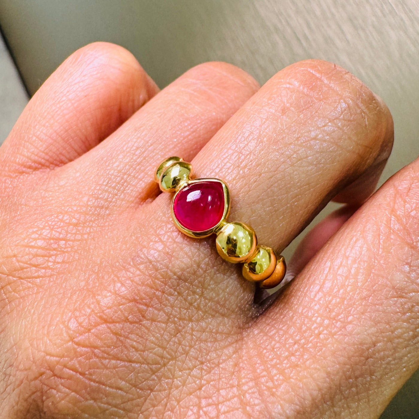 Ruby Round Ring In 18K Yellow Gold - Tresor Collection Close-up of 18K gold beaded ruby ring worn on hand – luxury artisan jewelry