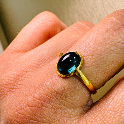 Blue Sapphire Oval Ring In 18K Yellow Gold - Tresor Collection Close-up of oval Blue Sapphire gemstone in bezel gold setting – artisan fine jewelry