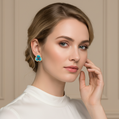 Woman wearing a pair of earrings with a neutral background Designer turquoise floral earrings styled for festive and bridal looks