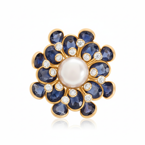 Jewelry item with blue stones and a pearl center on a white background