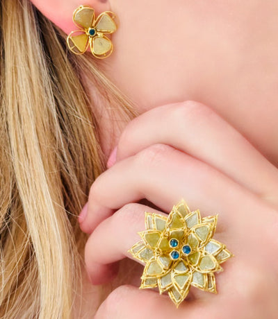 Elegant floral ring on model (side view) – 18K yellow gold statement ring with blue center stones by Tresor Collection