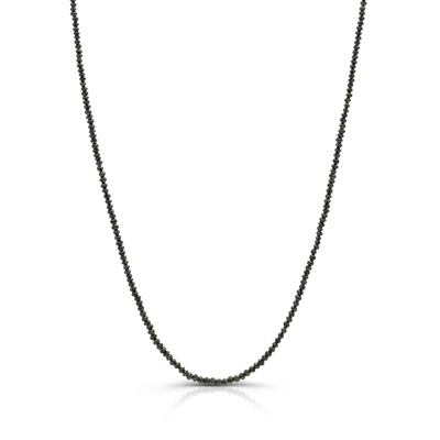 Close-up of 18k yellow gold necklace with 15.58 cts black diamond beads on white background. 18K gold black diamond bead necklace flatlay – luxury fine jewelry by Tresor Collection