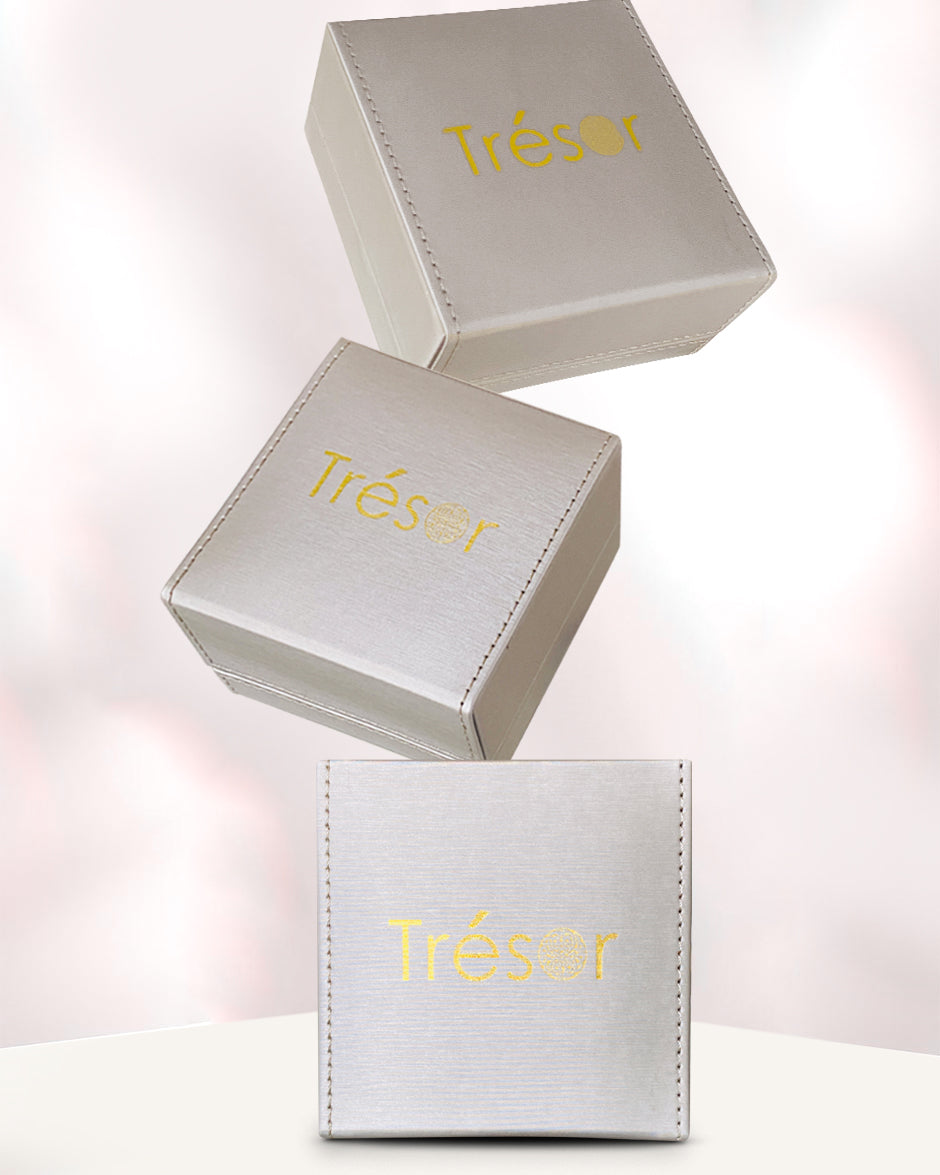 Three Trésor jewelry boxes stacked on a white background Tresor Collection packaging with tanzanite necklace – luxury handcrafted fine jewelry