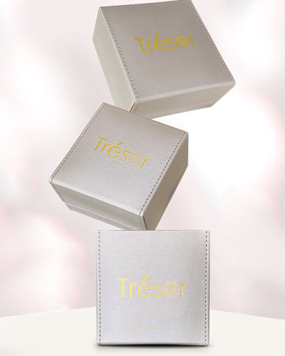 Three Trésor jewelry boxes stacked on a white background Tresor Collection packaging with tanzanite necklace – luxury handcrafted fine jewelry
