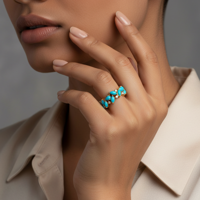 Close-up of a hand wearing a turquoise ring with a neutral  Elegant turquoise gold ring on model – designer fine jewelry for women by Tresor Collectionbackground