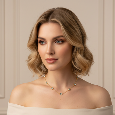 Woman wearing a delicate necklace against a neutral background Elegant aquamarine gold necklace on model – designer fine jewelry for women by Tresor Collection