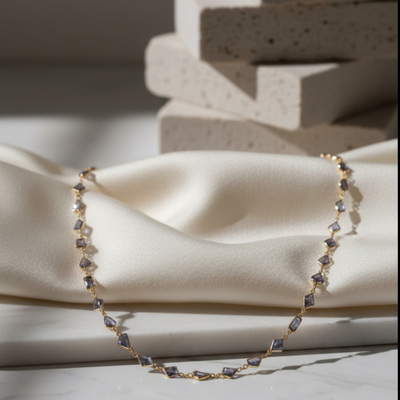 Delicate bracelet on a soft fabric surface with a neutral background Close-up of 18K gold blue sapphire necklace – handcrafted fine jewelry from Tresor Collection boutique