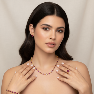 Woman wearing a necklace, earrings, and ring with a neutral background Rhodolite necklace styled for festive and bridal occasions – luxury handcrafted jewelry from Tresor Collection