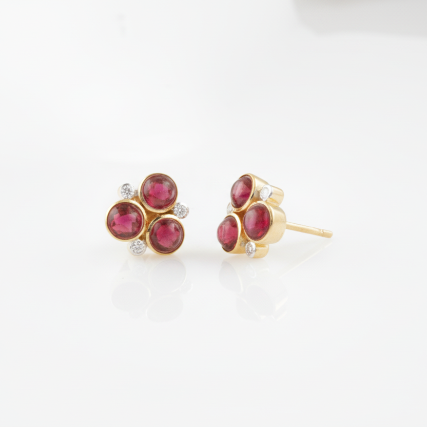 Pair of gold earrings with red gemstones on a white background 18K gold ruby and diamond floral earrings flatlay – luxury fine jewelry by Tresor Collection