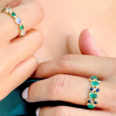 Close-up of hands wearing green gemstone rings. Close-up of 18K gold gemstone cabochon ring – handcrafted fine jewelry from Tresor Collection