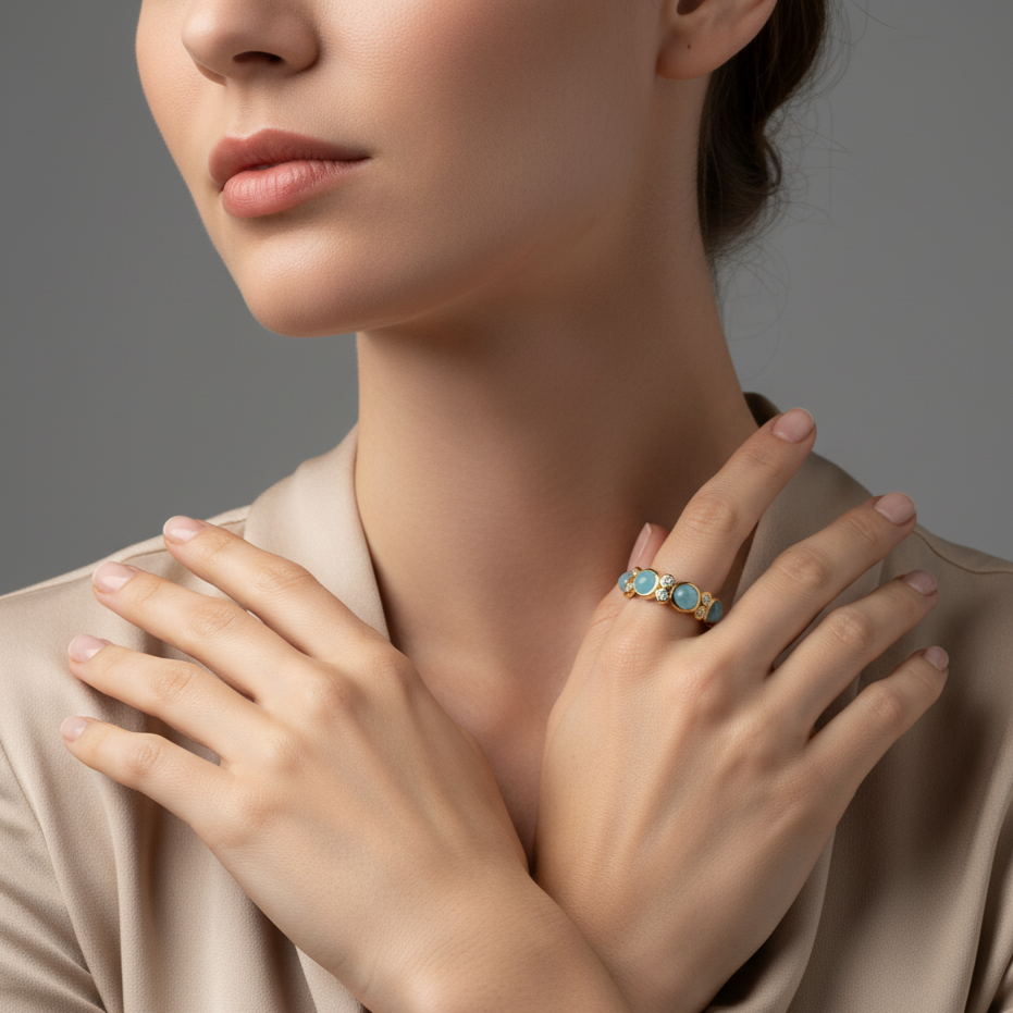 Close-up of a woman wearing a gold ring with blue gemstones on a neutral background Elegant aquamarine and diamond ring on model – designer gold jewelry for women by Tresor Collection