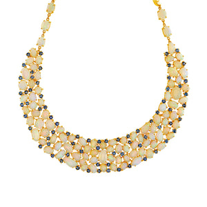 A yellow gold necklace featuring alternating ethiopian opal and blue sapphire gemstones. 18K gold Ethiopian opal and sapphire necklace flatlay – luxury handcrafted fine jewelry by Tresor Collection